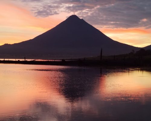 Toma de atardecer sobre laguna del Arenal en La Fortuna, colores naranja y negro predominando